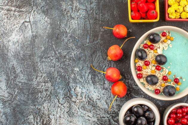 饮食顶部特写查看浆果樱桃五颜六色浆果燕麦片在碗在黑暗的桌子上特写健康樱桃
