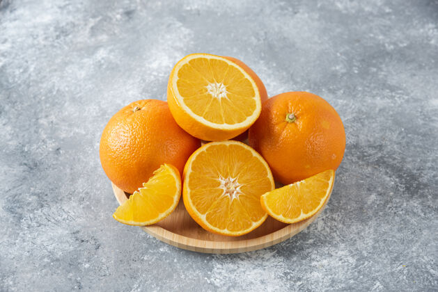 热带石桌上放满了橙子汁的木板圆形天然橙子