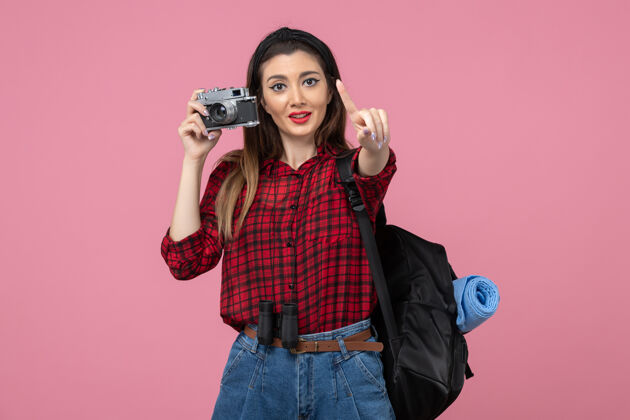 照片前视图年轻女性用相机在粉色背景上拍照女性颜色相机成人肖像
