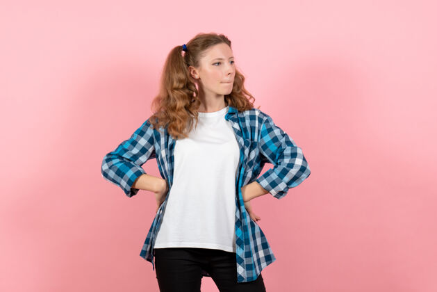 姿势前视图穿着格子衬衫的年轻女性在浅粉色背景上摆姿势模特情感年轻女性女孩孩子人年轻女性漂亮