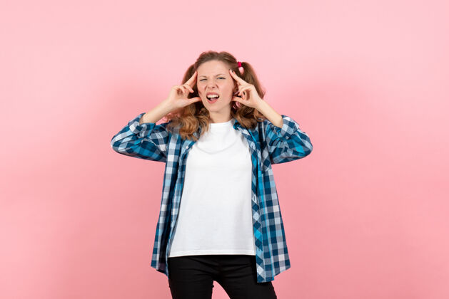 情感正面图穿着格子衬衫的年轻女性在粉色背景上摆姿势年轻模特情感女童女孩子女孩肖像