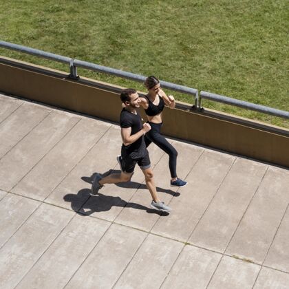 女人高角度的男女一起在户外慢跑锻炼男人慢跑
