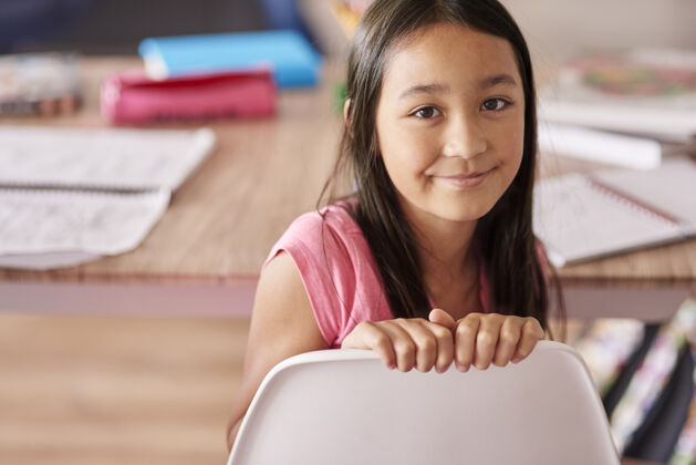 桌子坐在椅子上的亚裔女孩技能笔记本学生
