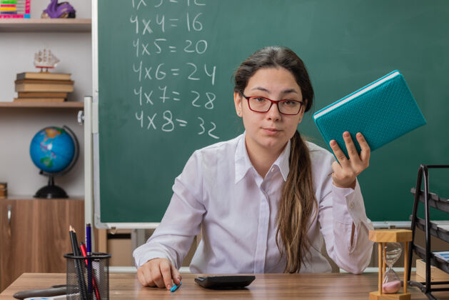 课年轻的女老师戴着眼镜拿着笔记本教室眼镜年轻