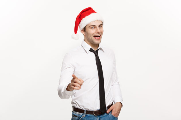 快乐英俊的商人戴着圣诞帽指着白色的手指感觉亚洲人圣诞老人