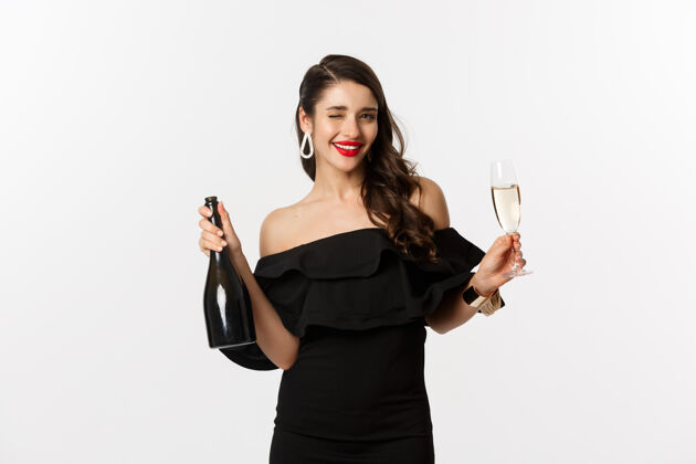 格拉斯庆祝和派对的概念时尚的黑发女人穿着迷人的裙子 拿着一瓶香槟和一杯香槟 在新年假期里玩得很开心表情服装女人