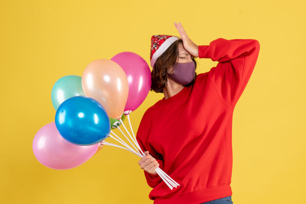 女人正面图：戴着黄色面具手持气球的年轻女子磁盘骑师派对庆祝