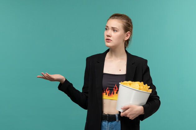 西装正面图年轻女性在蓝色的水面上吃薯片看电影观看电影土豆