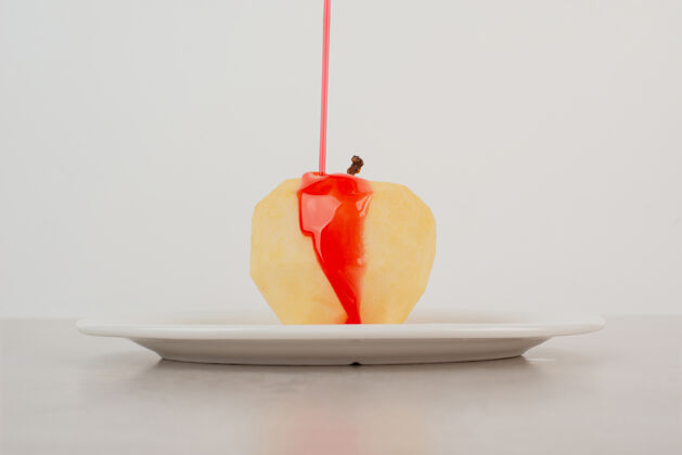 糖浆在白盘子里用糖浆浇苹果红色食物可口
