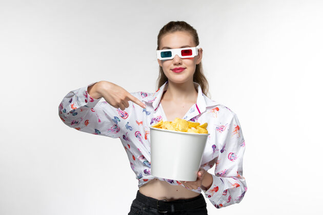 抱着正面图：白色表面上戴着d型太阳镜的年轻女性拿着土豆片的篮子太阳镜享受孤独