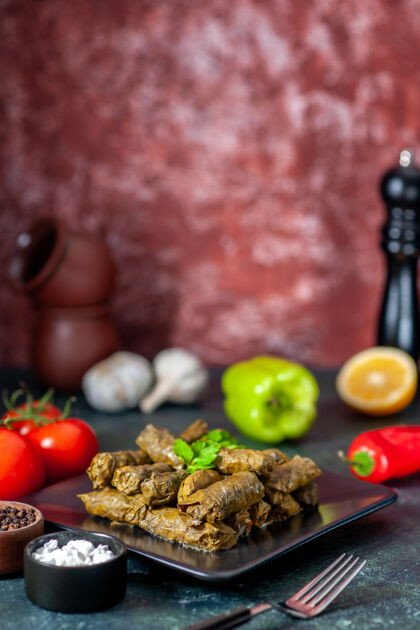 肉前视图美味的叶子与黑暗背景上的西红柿多尔玛卡路里油晚餐食品沙拉菜肉类餐厅餐盘子菜菜