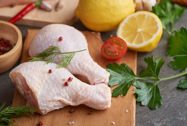 烹饪用新鲜调味料烹调和烧烤用的新鲜鸡肉部分切菜板上的生鸡腿餐桌准备营养
