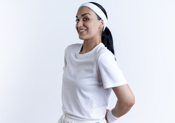 运动年轻焦虑的高加索运动女性戴着头带和腕带站在一边 手牵着手 身后是一片空白 空白处有复制空间复制腕带戴着