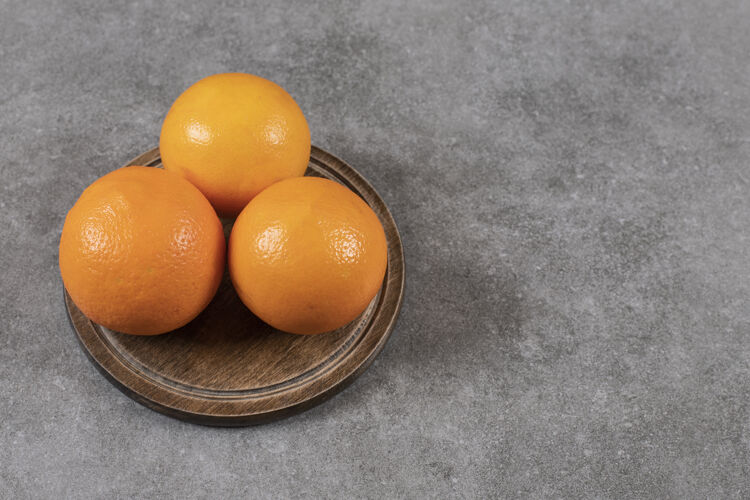 食物灰色桌子上方木板上熟透的橙子的特写照片部分柑橘黄色