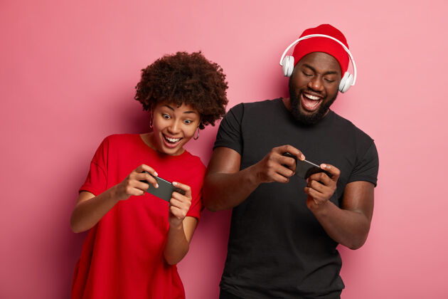 战斗快乐的美国黑人女朋友和男朋友玩手机游戏 参加网上比赛 一起玩得开心虚拟上瘾赢家