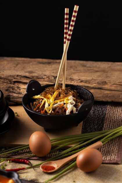 食物木桌上一碗美味佳肴和筷子的垂直镜头豆类碗菜