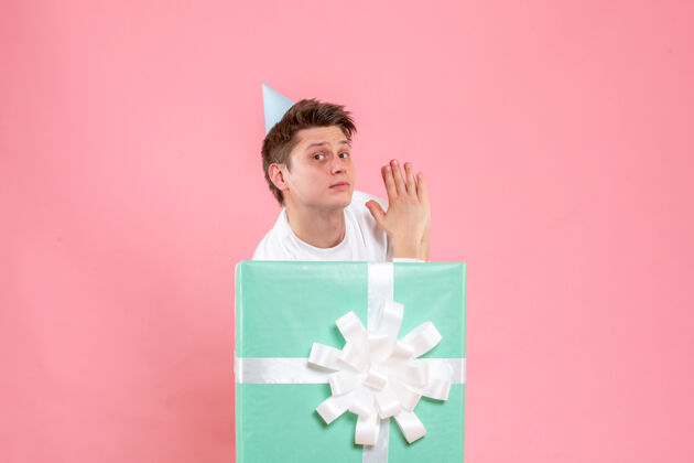年轻男性正面图：身穿白色衬衫 头戴鸭舌帽 粉色背景的年轻男性风景情感圣诞节