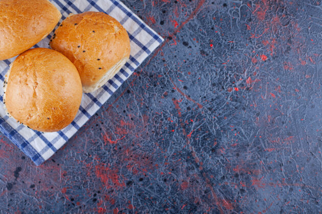 准备新鲜的面包和条纹桌布放在大理石表面食物谷物桌布