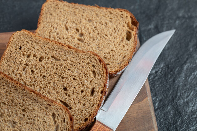 餐在木板上放几片新鲜的面包硬皮板小麦