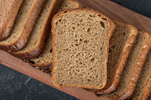 硬皮有面包片的木制砧板小麦面包健康