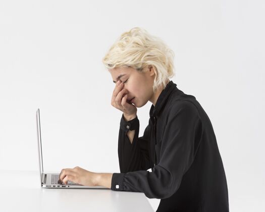 年轻中枪疲惫的女人在笔记本电脑上工作科技中景创新