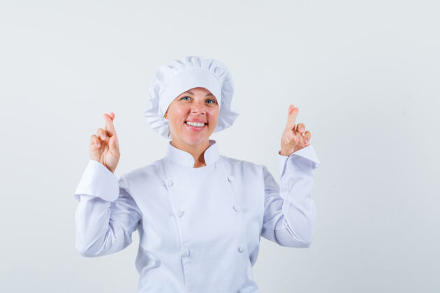 女人一位身穿白色制服的女厨师手交叉着手指 看上去很快乐休闲眼睛现代