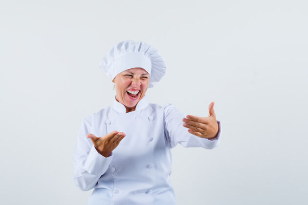 欢乐一个穿着白色制服的女厨师一边笑一边看着电话 看起来很有趣嘴唇而女性