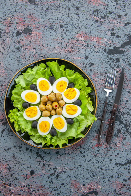 沙拉俯视图美味的鸡蛋沙拉由绿色沙拉和橄榄组成 背景色浅碗餐蔬菜
