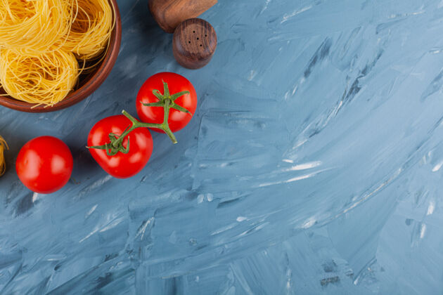 平铺意大利通心粉配新鲜的红番茄和香料堆Fettuccine健康