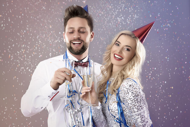 香槟一对年轻夫妇在庆祝新年前夜优雅火花五彩纸屑