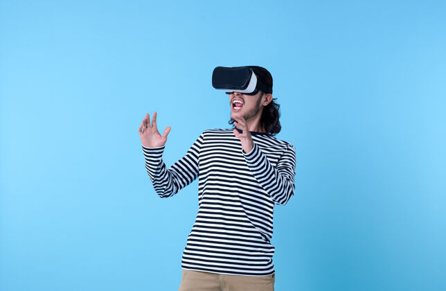 计算机兴奋的亚洲人戴着虚拟现实护目镜看蓝色电影兴奋视频娱乐