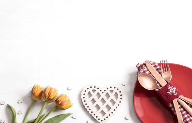 餐桌布置用盘子和餐具组成浪漫的情人节晚餐约会概念装饰鲜花餐具
