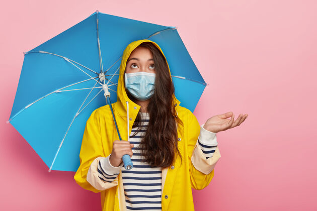 雨衣严肃的黑发女人举起手掌 戴上防毒防病的医用口罩韩国人室内疾病