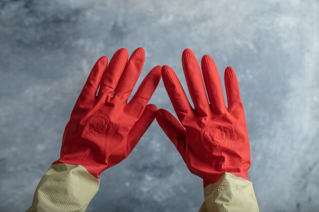 家用在大理石上戴着红色防护手套的女性手手清洁化学品