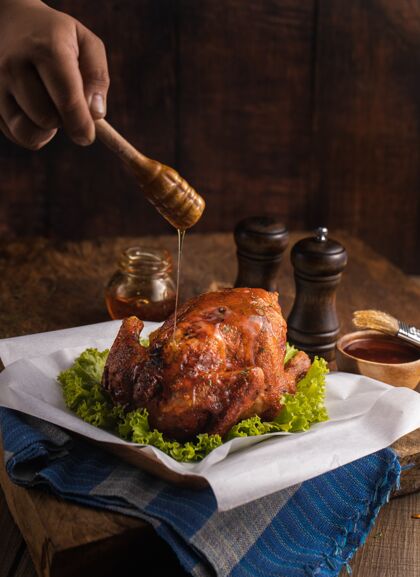 猪肉垂直拍摄的美味烤鸡肉点缀着蔬菜和蜂蜜在一张桌子上菜晚餐酱汁