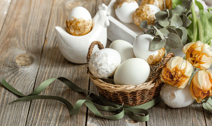 复活节彩蛋复活节假期的节日组成与新鲜的春天鲜花和鸡蛋复活节装饰概念花瓶构图特写