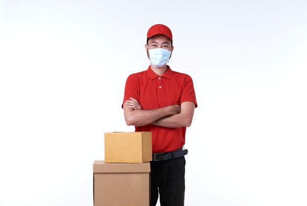 男性亚洲送货员戴着红色制服的口罩和白色包裹盒成人盒子衣服