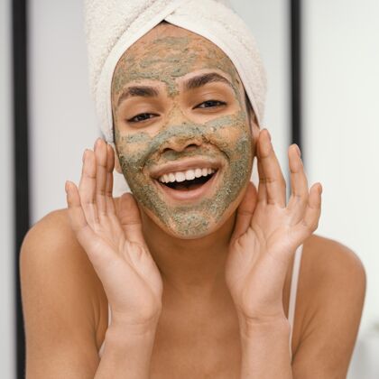卫生脸上戴着自制面具的快乐女人治疗自然自我护理