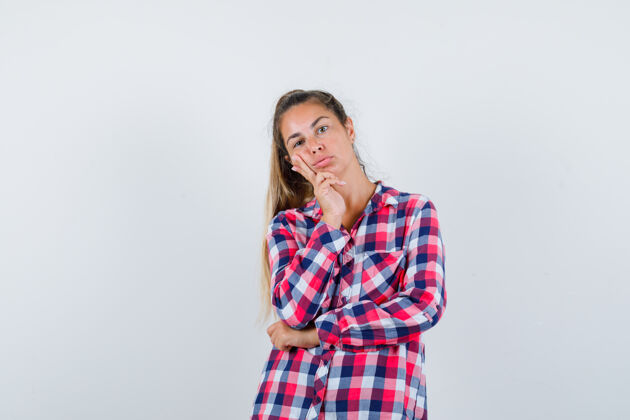 成人年轻女子穿着休闲衬衫站在思考姿势的肖像 看起来很感性的前视图手一个衬衫
