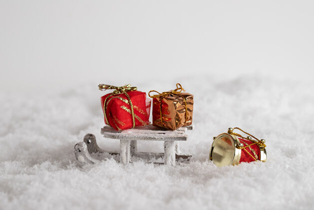 圣诞节雪地里的雪橇和彩色礼品盒特写镜头 白色背景下的圣诞玩具雪橇欢乐心情