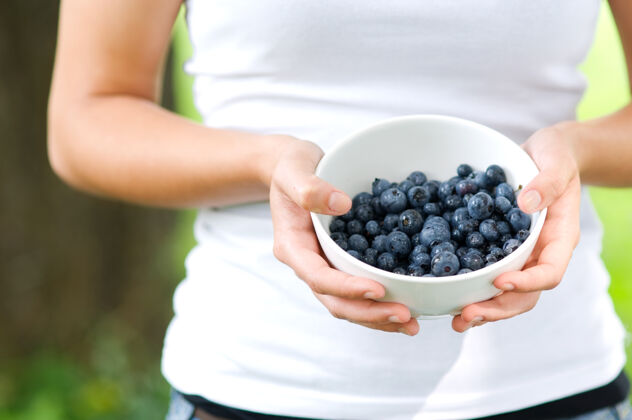 新鲜拿着满满一碗蓝莓的女人收获健活方式户外
