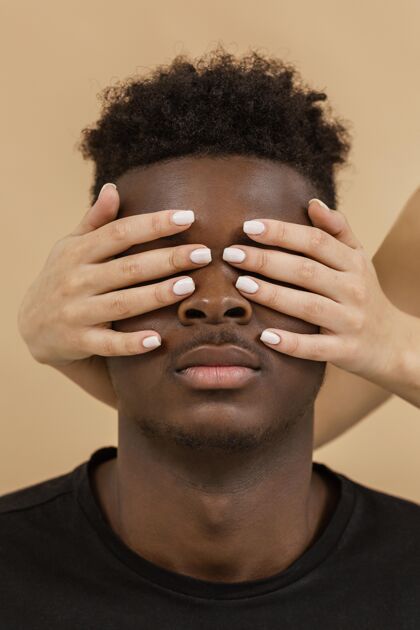 运动闭上双手遮住男人的眼睛没有种族主义黑人男子白人妇女