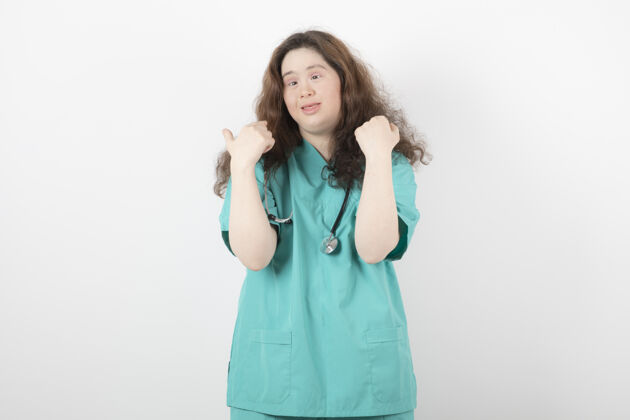 女人穿着绿色制服 手持听诊器站着摆姿势的年轻女孩姿势图片女性