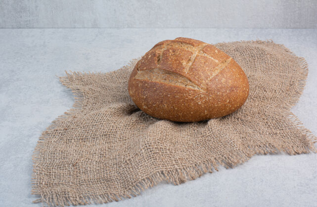 小麦自制黑麦面包在大理石背景上的粗麻布上高品质照片面包黑麦面包房