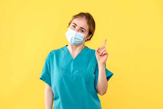 冠状病毒正面图黄色背景上戴着面罩微笑的女医生卫生院大流行柯维德面具封面成人