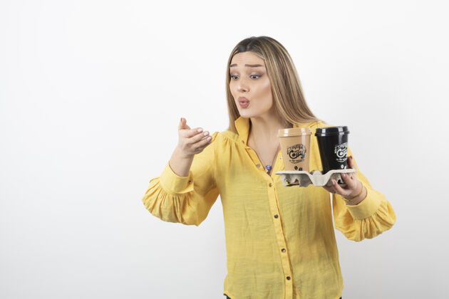 咖啡一幅年轻女子拿着咖啡在白色背景上看着她的手的画像茶年轻人人