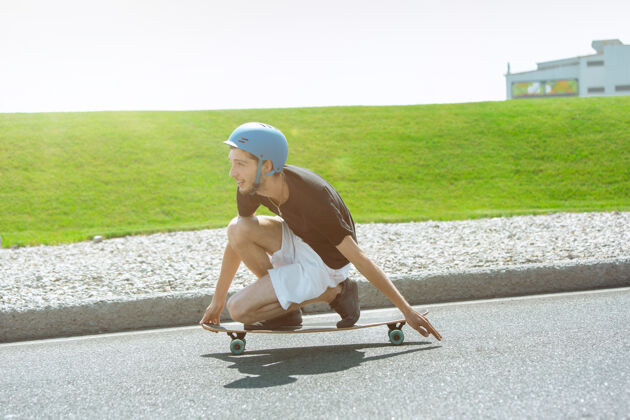 男孩在阳光明媚的日子里 滑板运动员在城市的街道上玩花样公园棋盘沥青