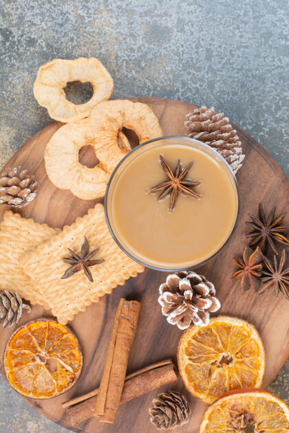 水果一杯咖啡 肉桂棒和松果放在木盘上高质量的照片干的松果咖啡