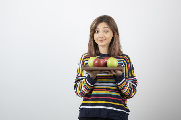 年轻可爱的年轻女子 穿着休闲服 手里拿着五颜六色的苹果模特抱看