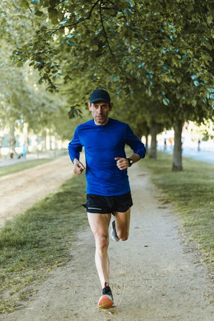 运动服一个男人在街上跑步的垂直镜头-健康的生活方式决心身体男性